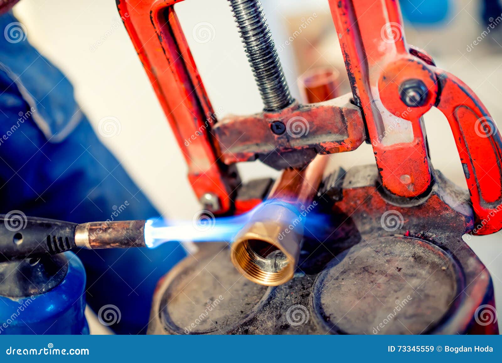 professional plumber welding copper and fittings with blowtorch