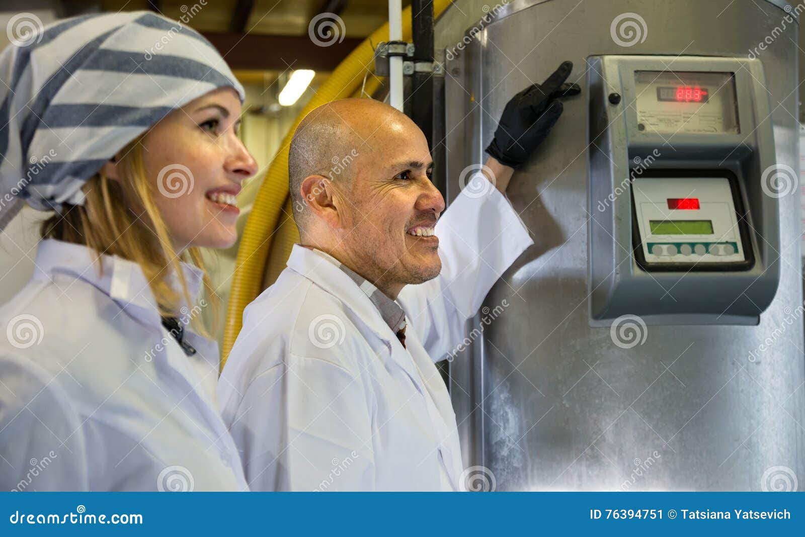 professional staff posing near machine in modern fabrica
