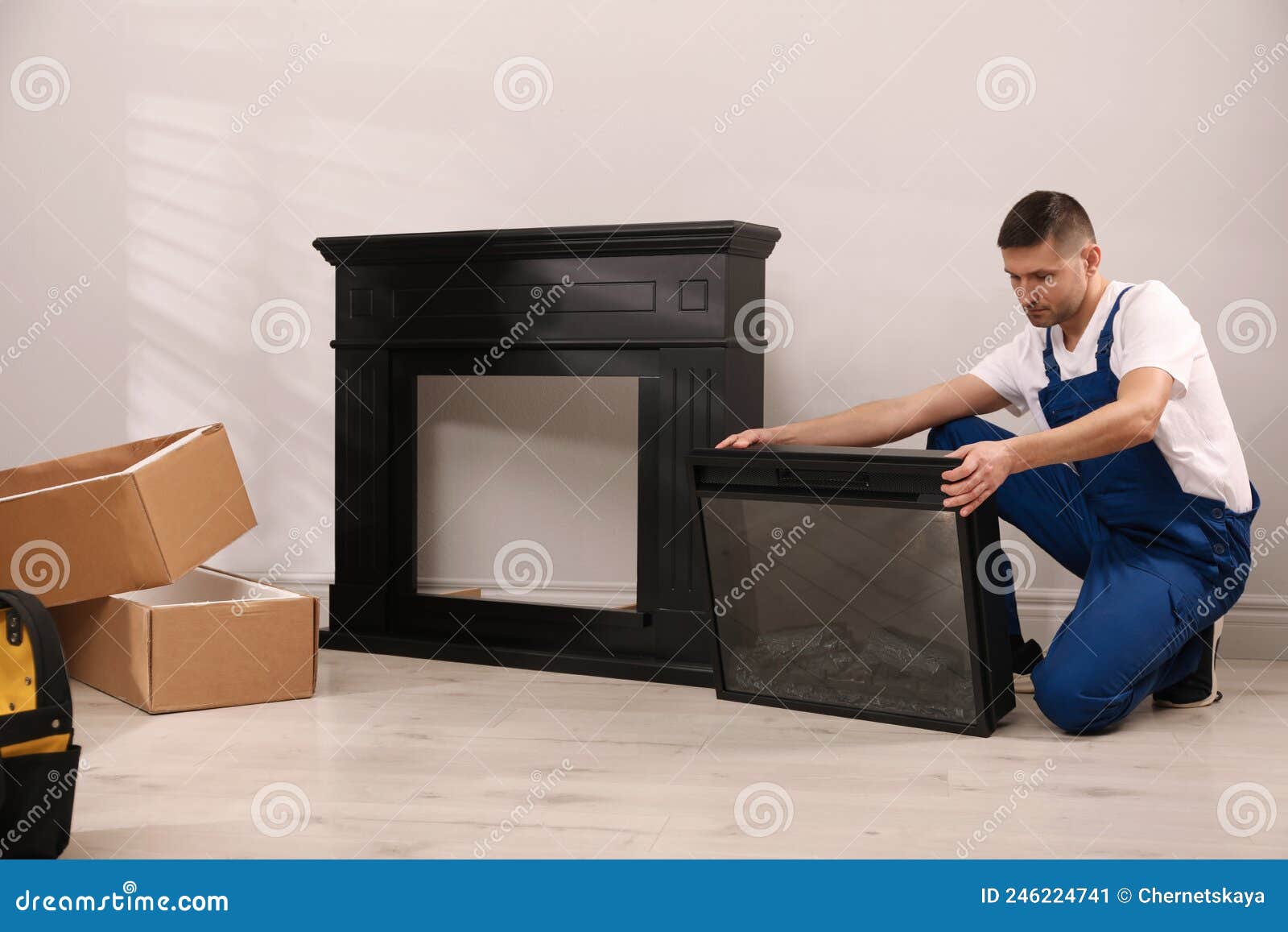 Professional Technician Installing Electric Fireplace in Room Stock