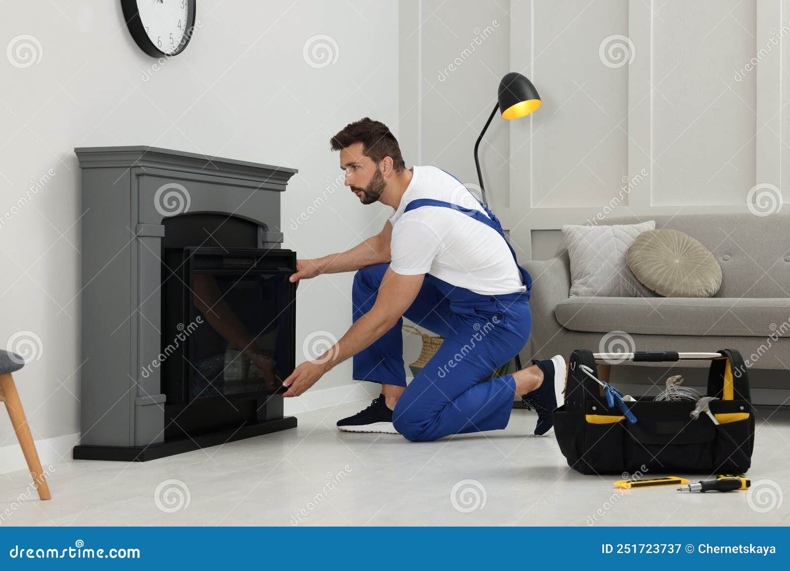 Professional Technician Installing Electric Fireplace in Room Stock