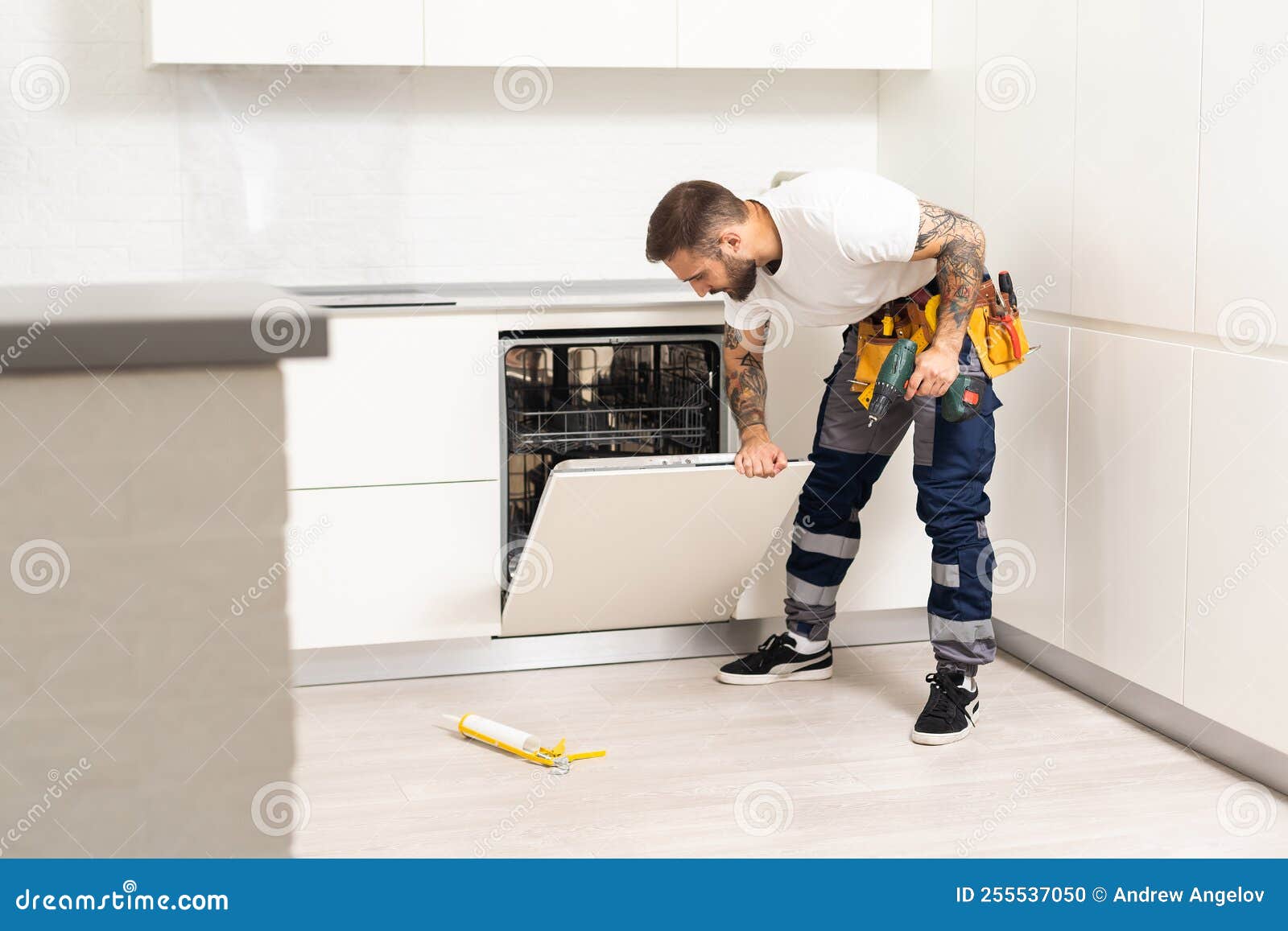Professional Worker Estimating Cost for Broken Dishwasher Stock Photo