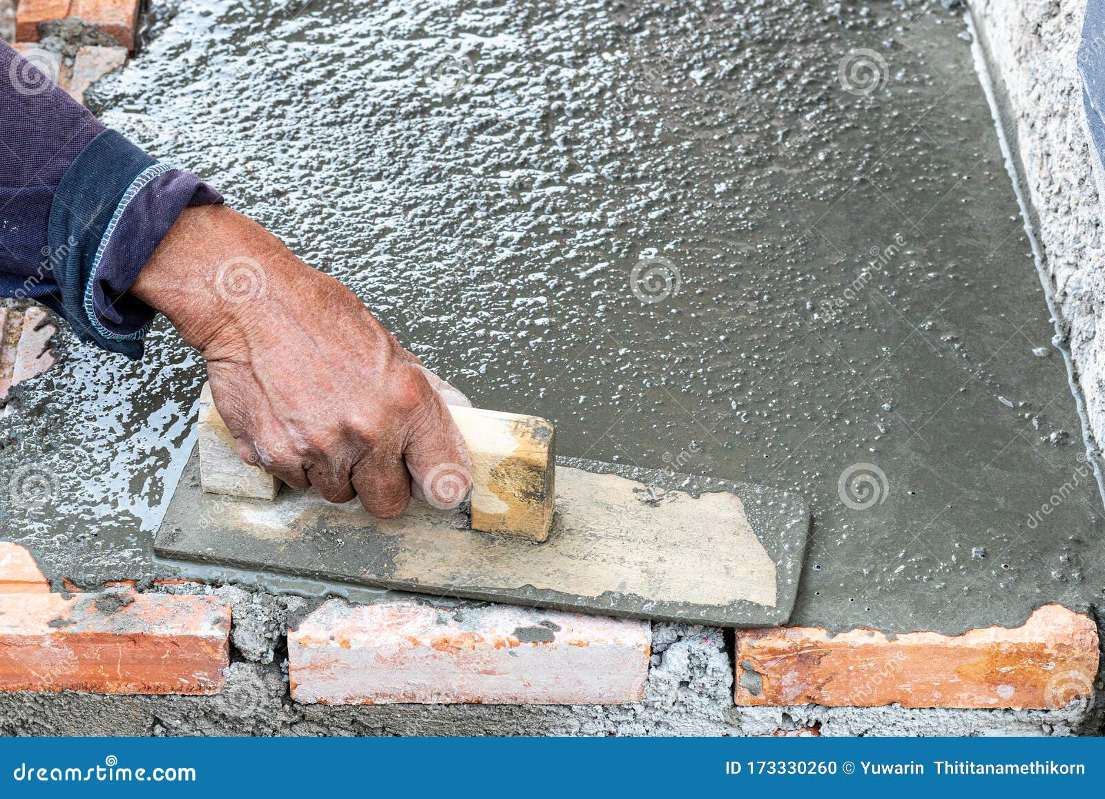 Professional Worker Using Trowel for Building Cement Floor. Stock Photo