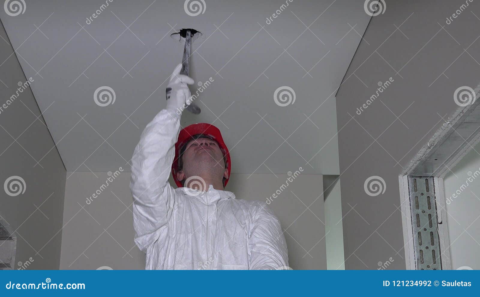 Professional Worker In Work Wear Make Drywall Ceiling Holes For Light Install