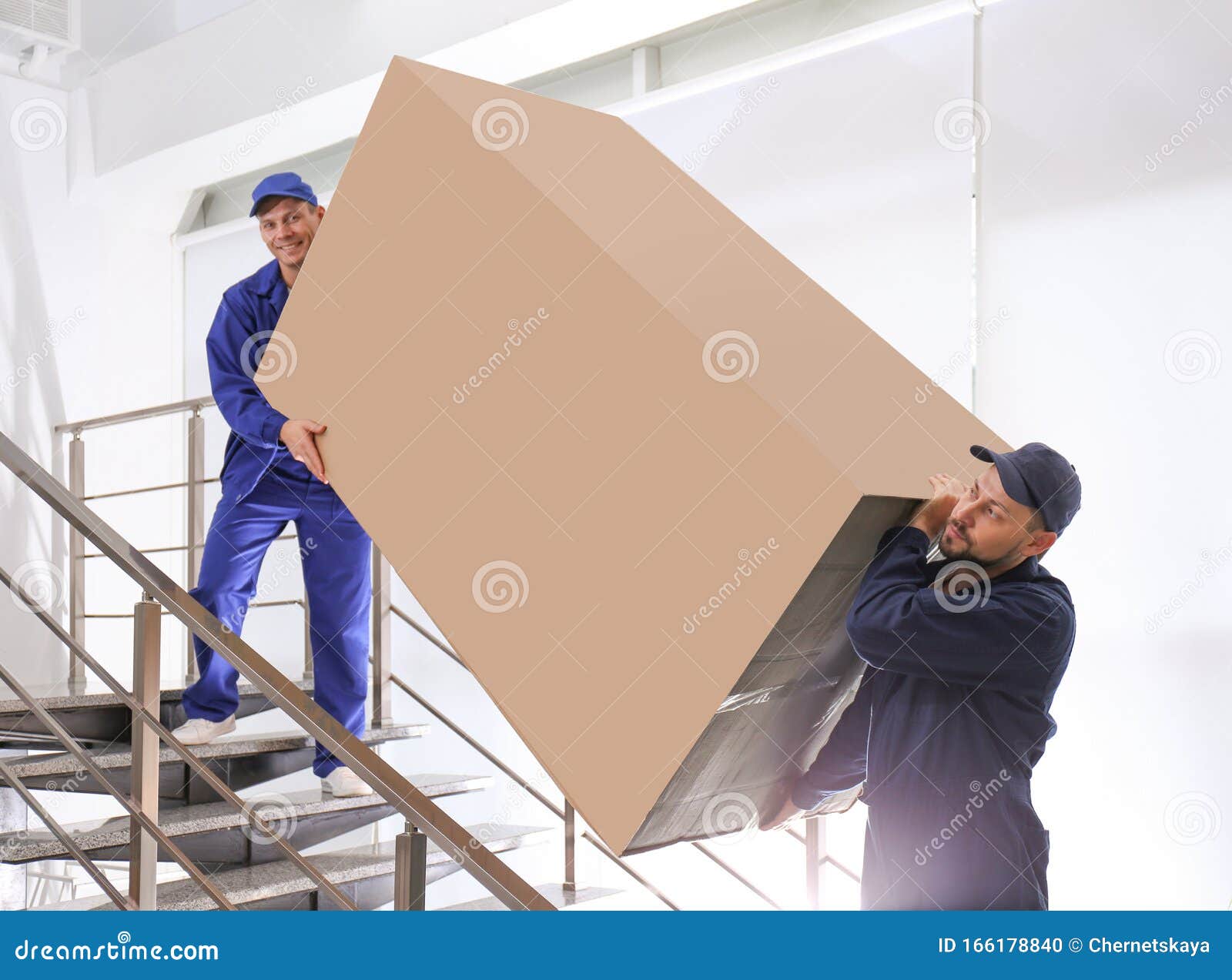 Professional Workers Carrying Refrigerator on Stairs Stock Photo
