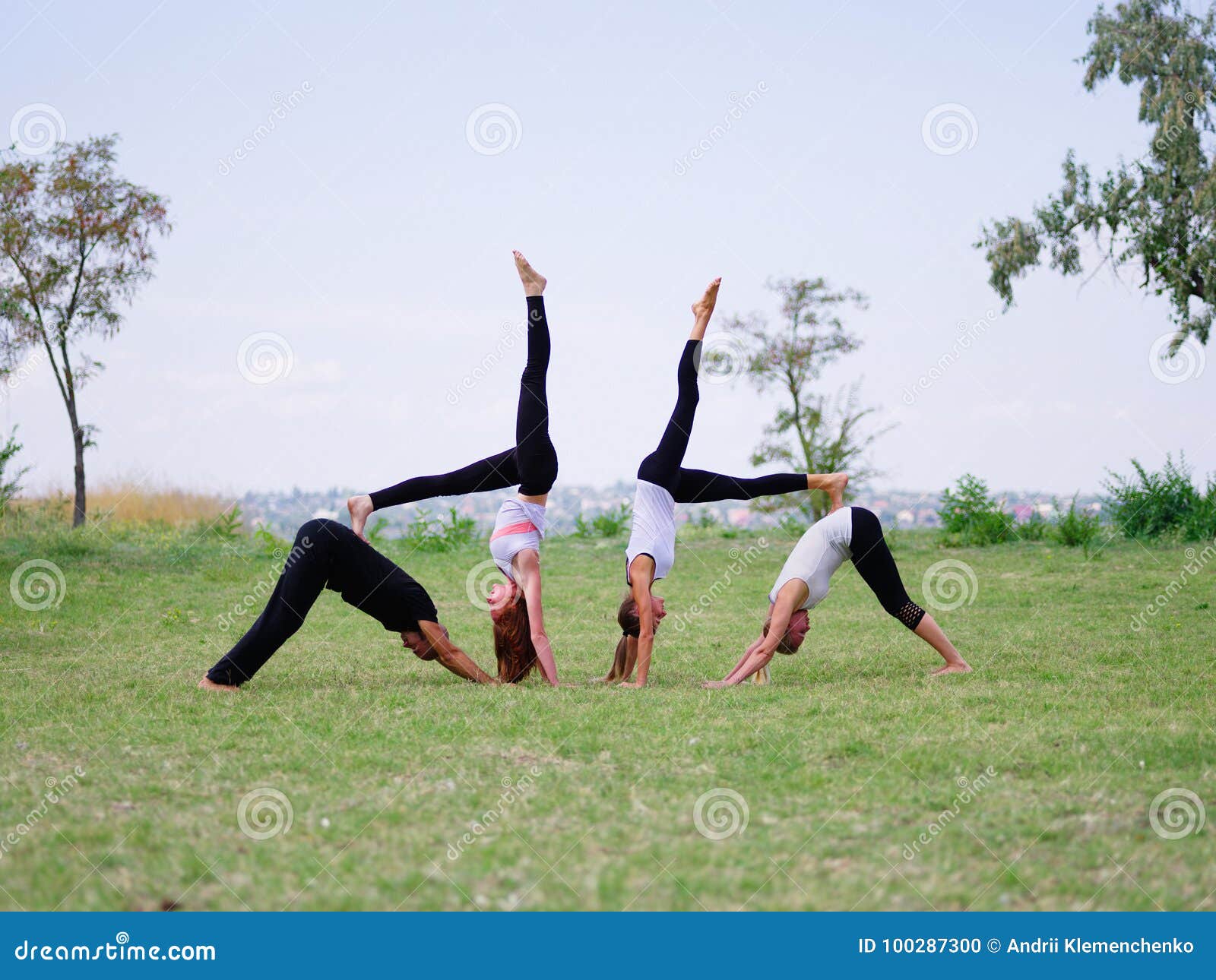 A Group of Four Holds Yoga Classes in the Park. Healthy Lifestyle