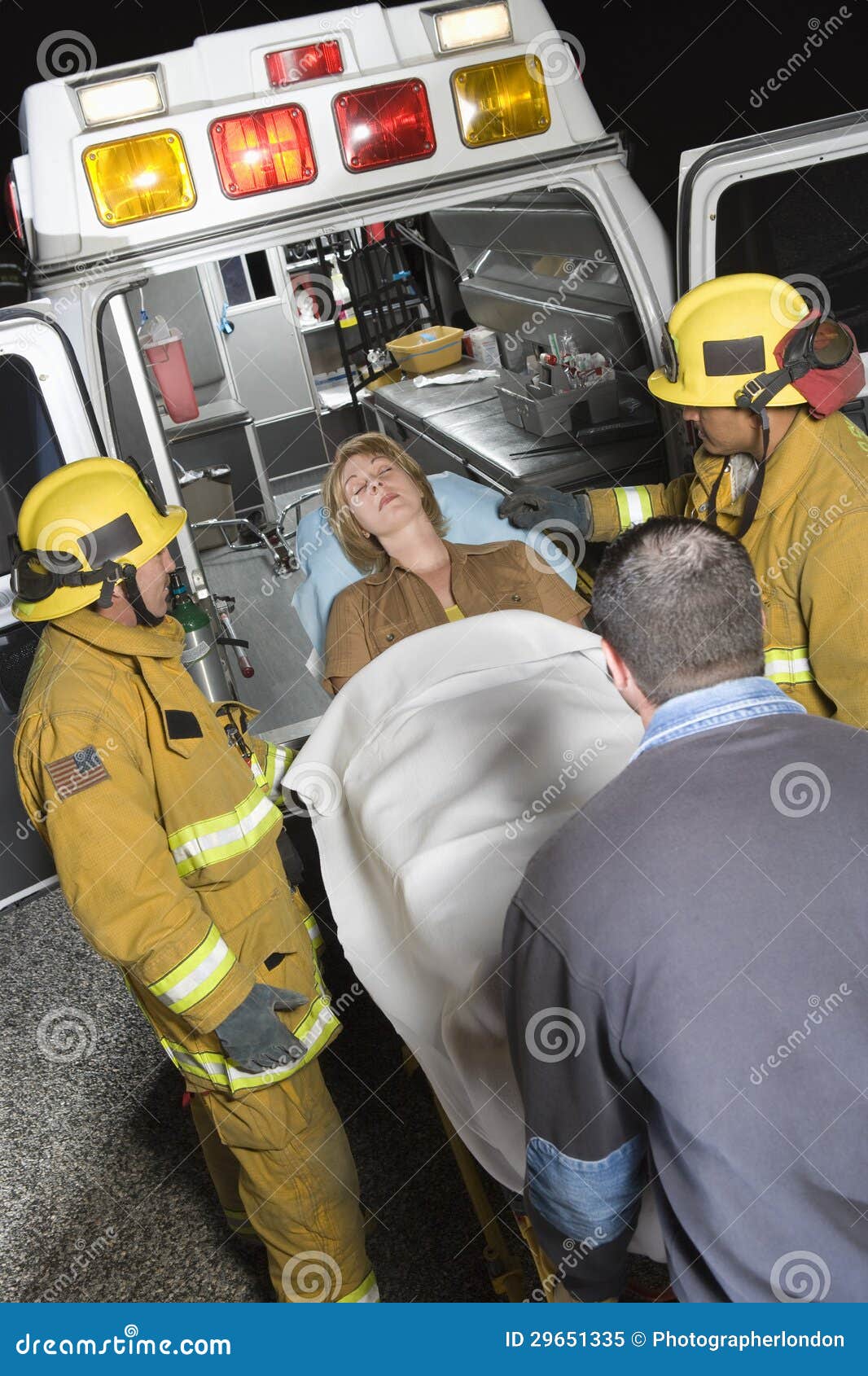 Professionals Carrying Patient on Stretcher in Ambulance Stock Image
