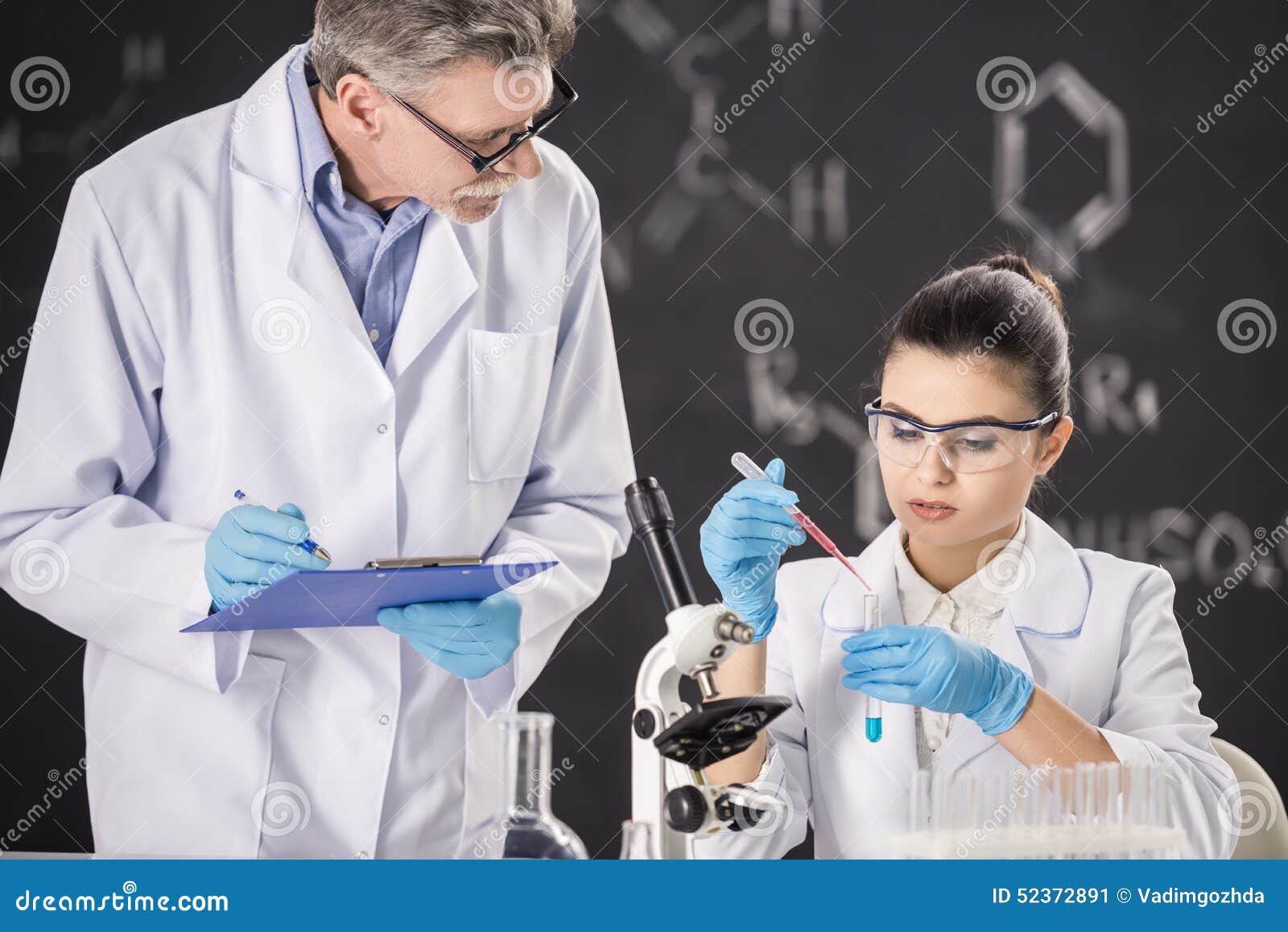 Professore senior di chimica e suo l'assistente che lavorano nel laboratorio