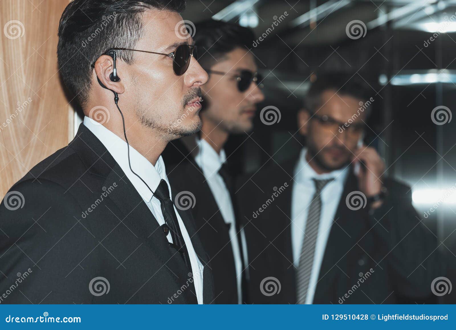 profile of bodyguards in sunglasses and businessman