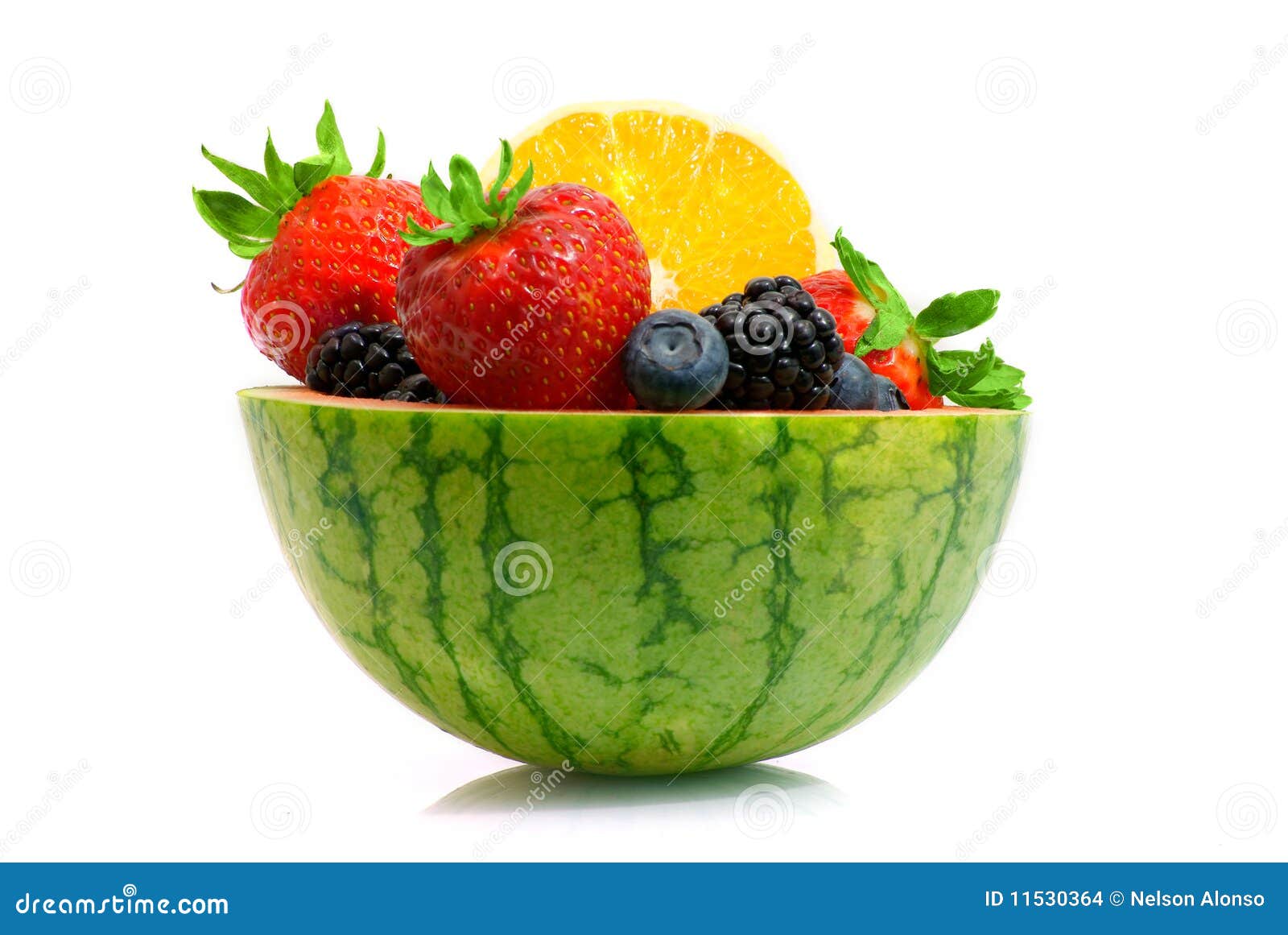 Profile of melon fruit bowl. Melon carved as bowl filled with orange and different berries