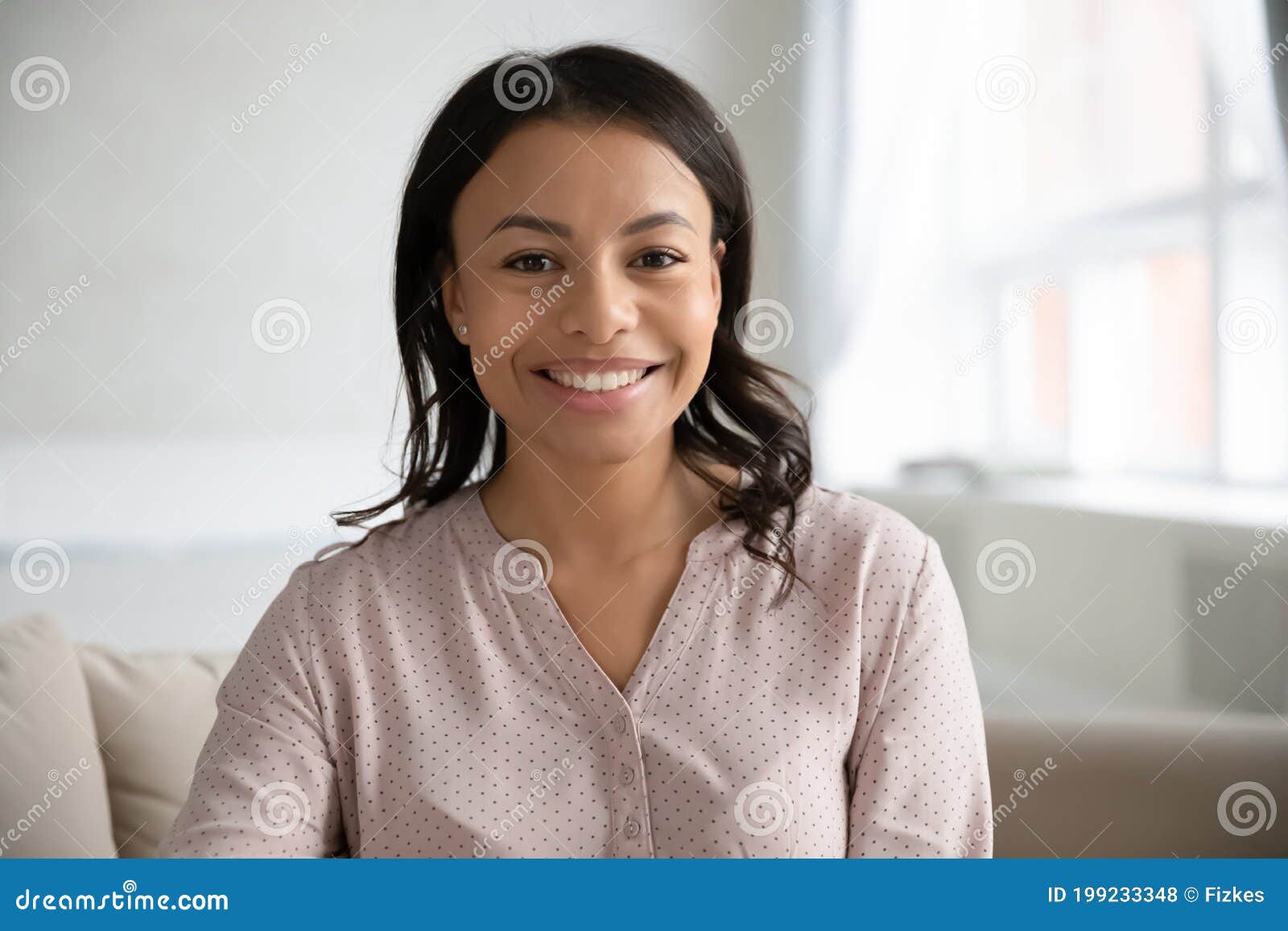 headshot portrait of smiling biracial woman posing at home