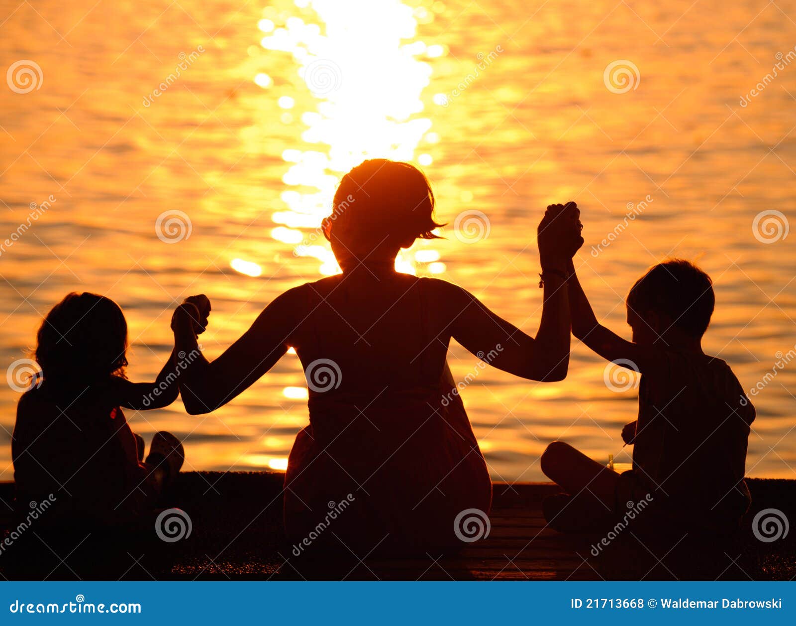 profiles of mother and children at sunset