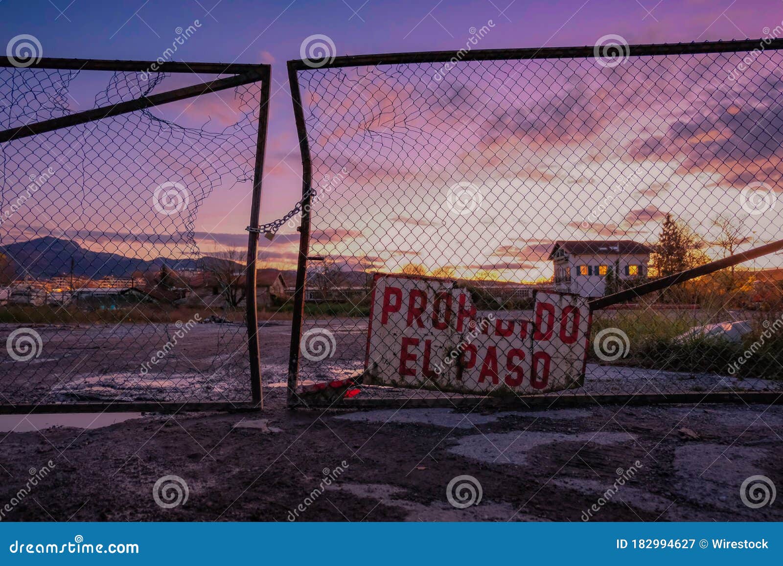 prohibido el paso sign on an old fence during sunset