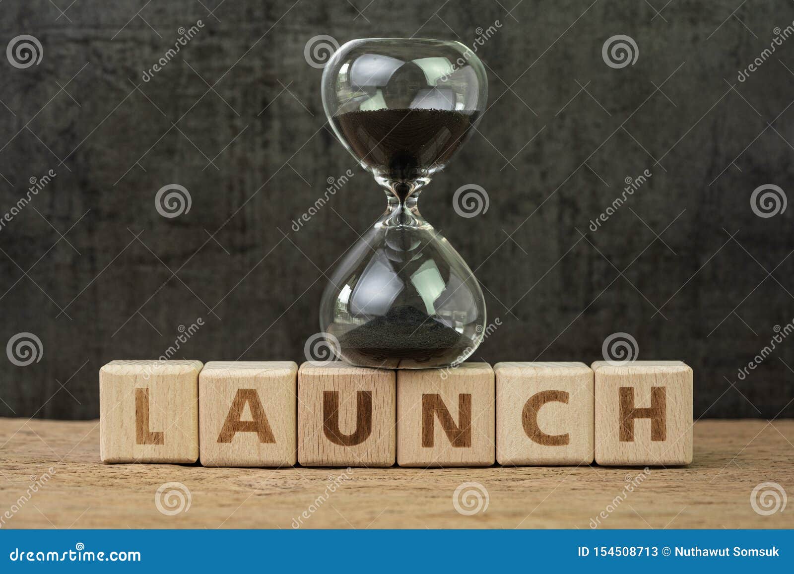 project launch countdown, start business or start up company, hourglass or sandglass on wooden cube block with alphabet building