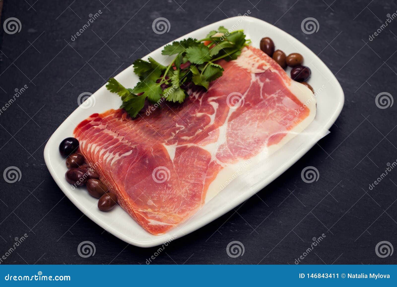 Prosciutto with Olives and Parsley on White Dish on Ceramic Background Stock Image Image of