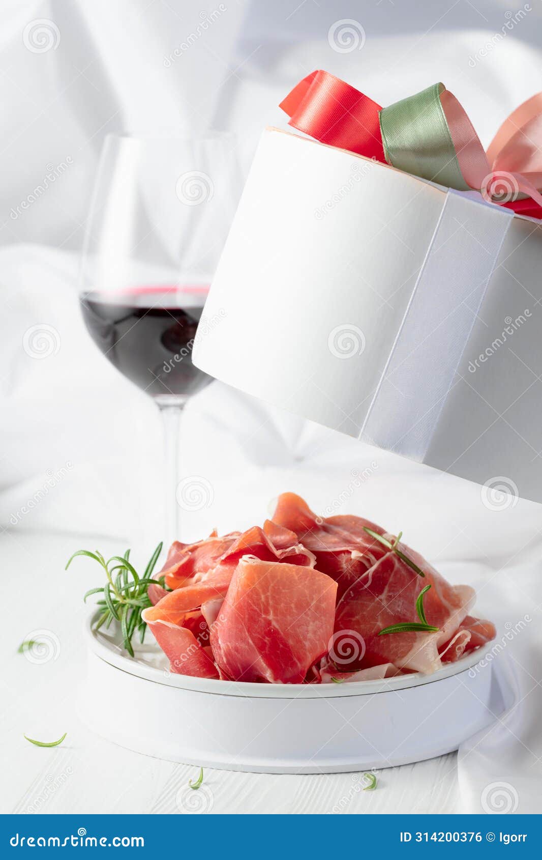 Prosciutto with Rosemary in Gift Box and Glass of Red Wine on a White ...