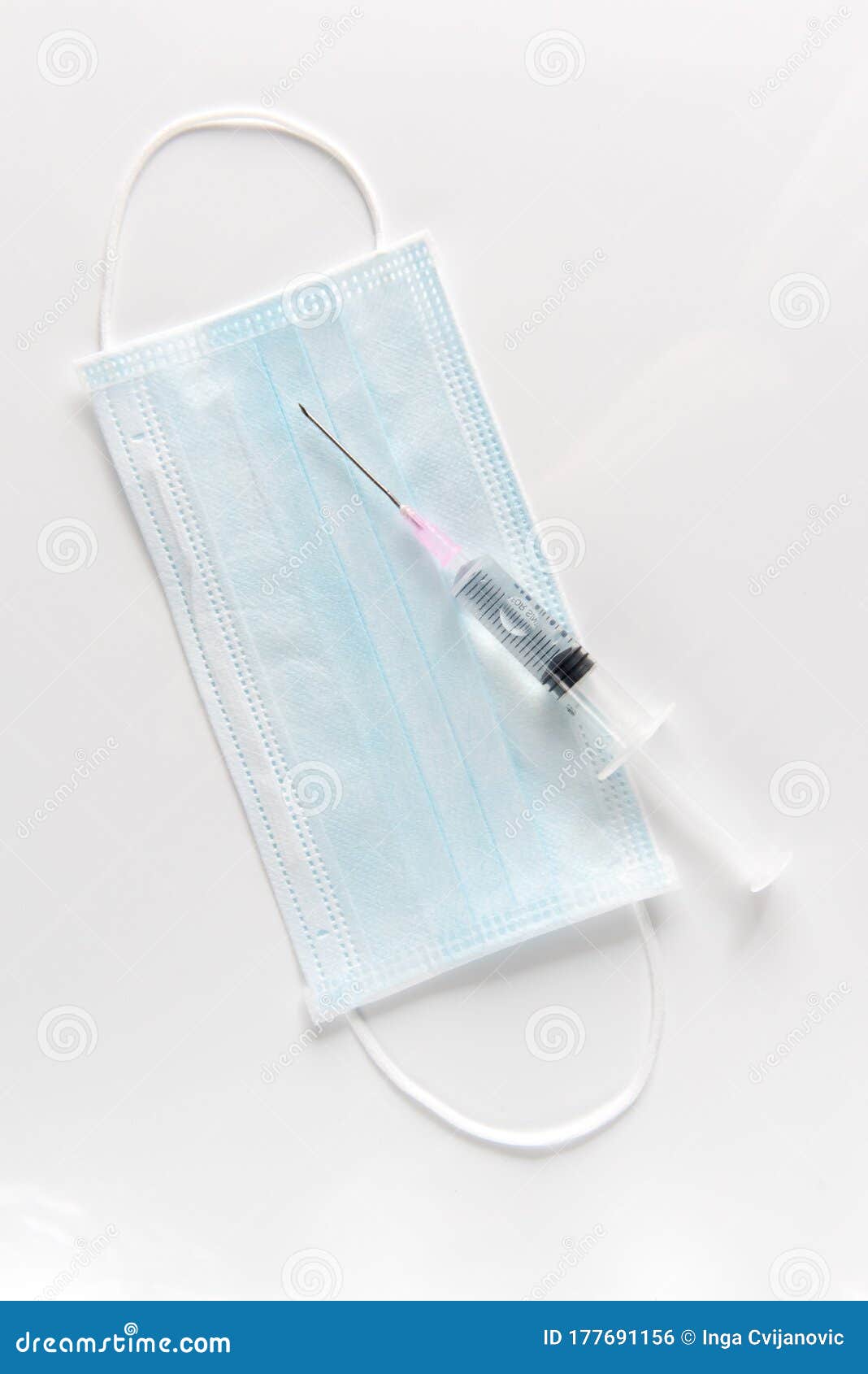 protective surgical mask, syringe on a white table