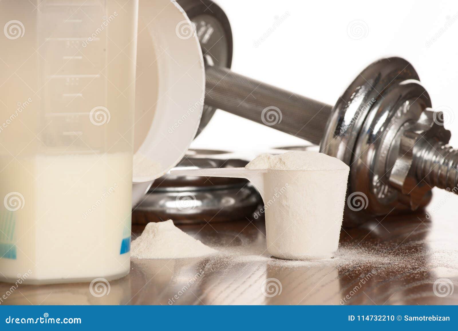 Protein Powder in Scoope with Dumbbells in Background - Whey Stock