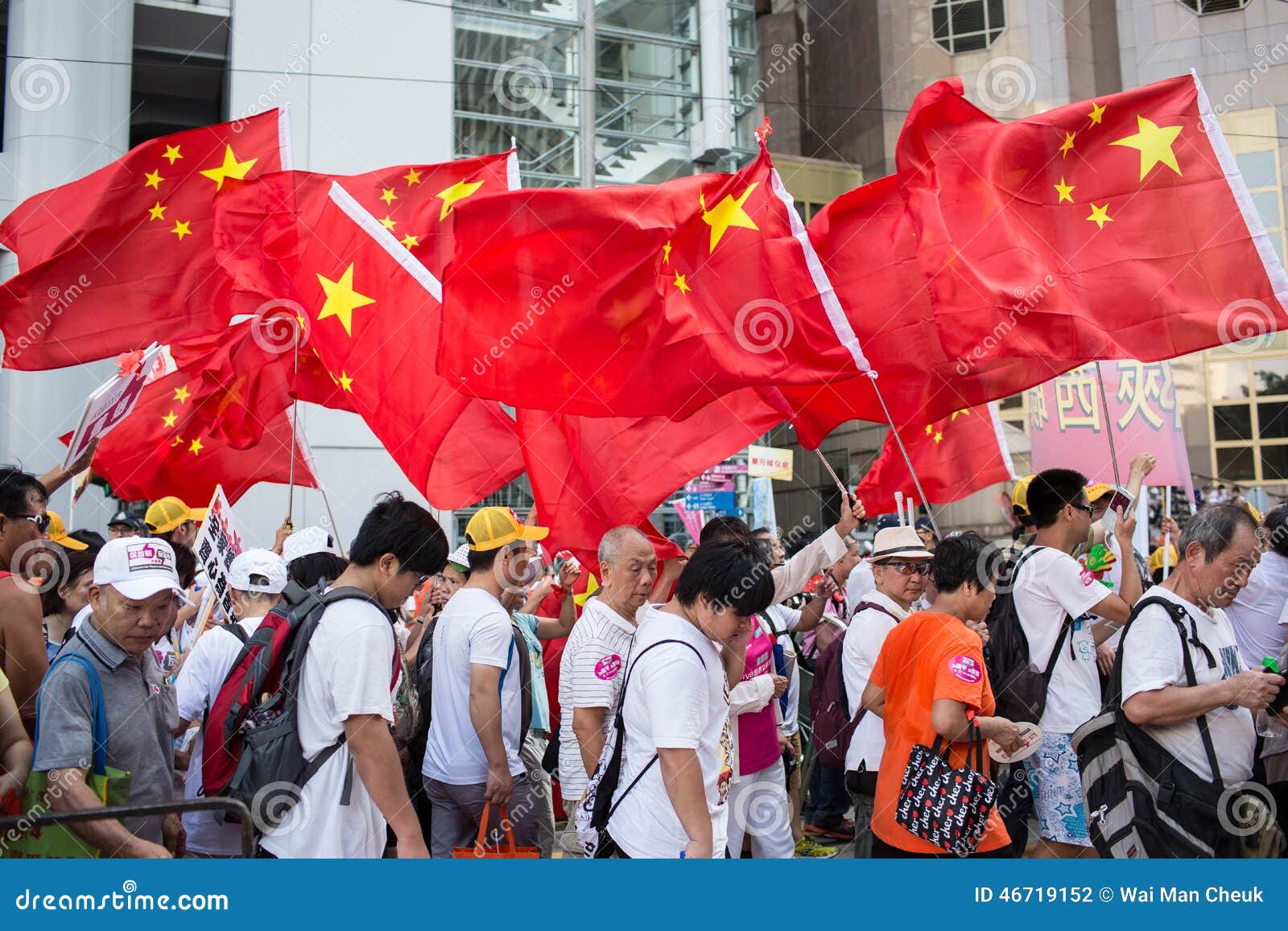 Protestation de Hong Kong Oppose Occupy Central. Les activistes de groupe de Pro-Pékin tiennent le drapeau national chinois et la marche sur une rue du centre à s'opposer occupent le central au central, Hong Kong, dimanche 17 août 2014