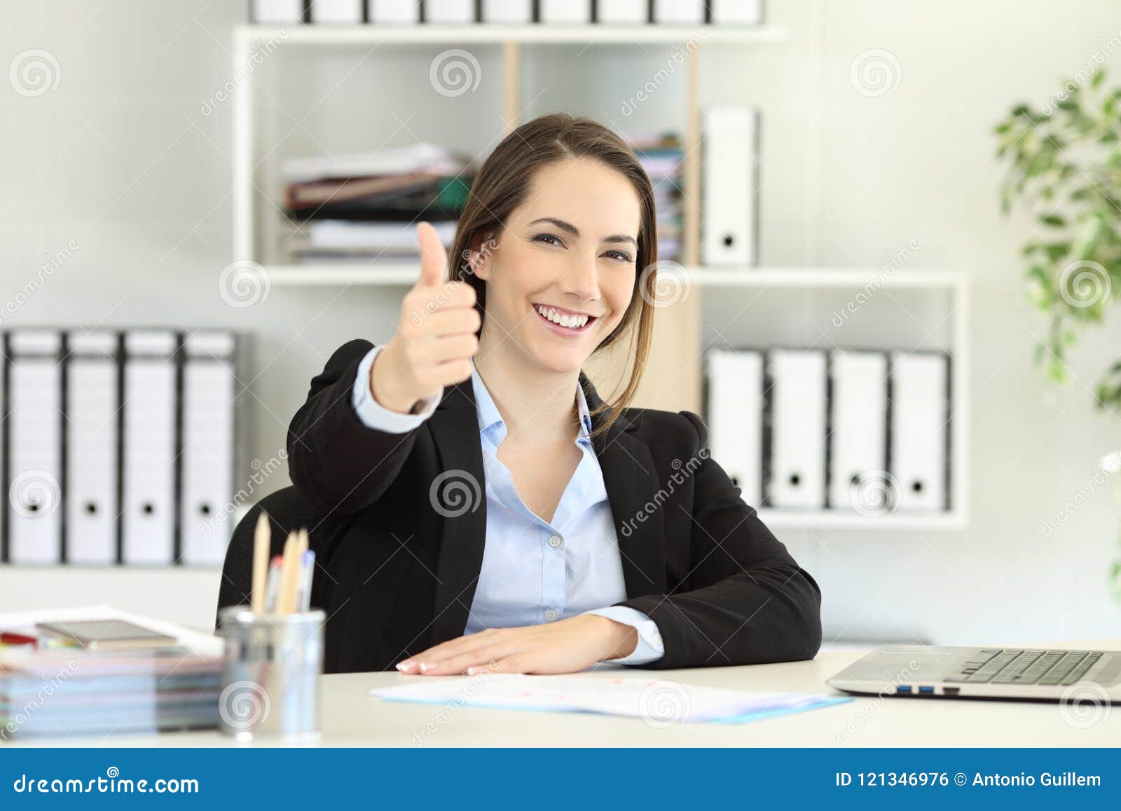 proud office worker posing with thumbs up