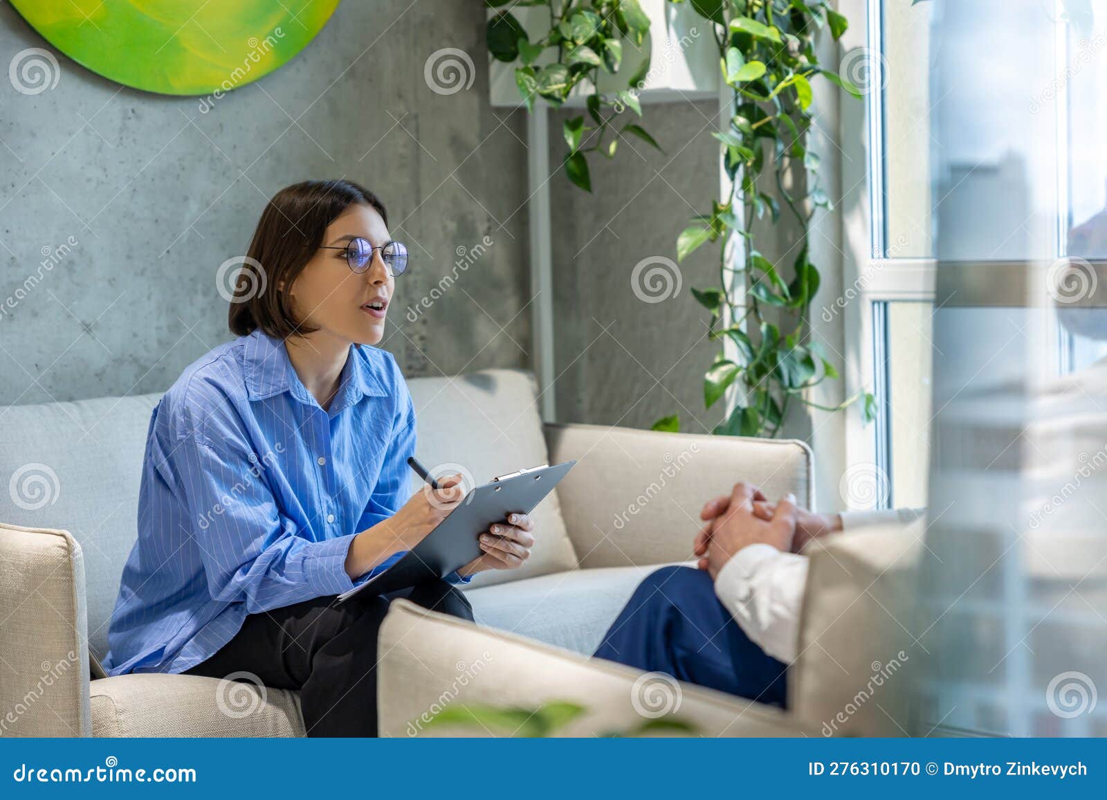 Psychologist Having a Sessiona with a Couple and Making Notes Stock