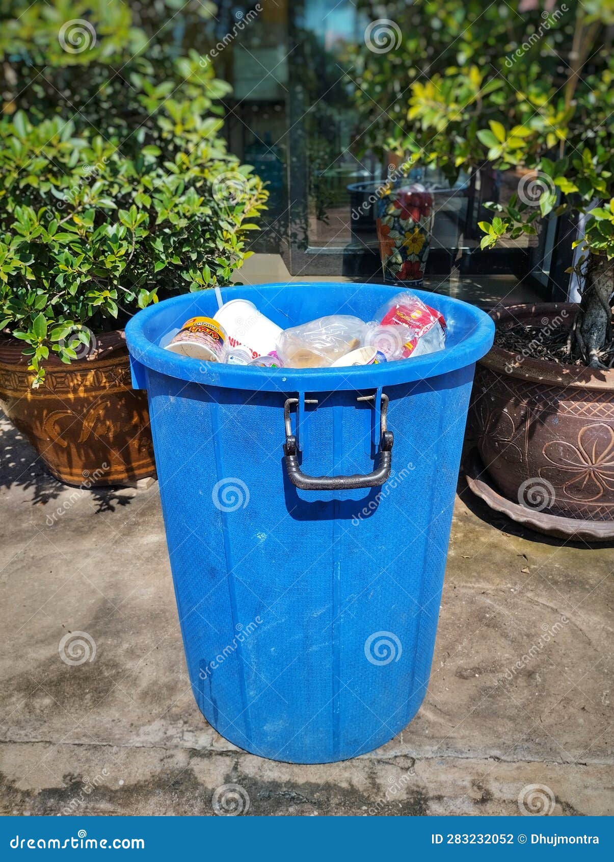 Blue Trash with Garbage is in Front of the Parking. Editorial