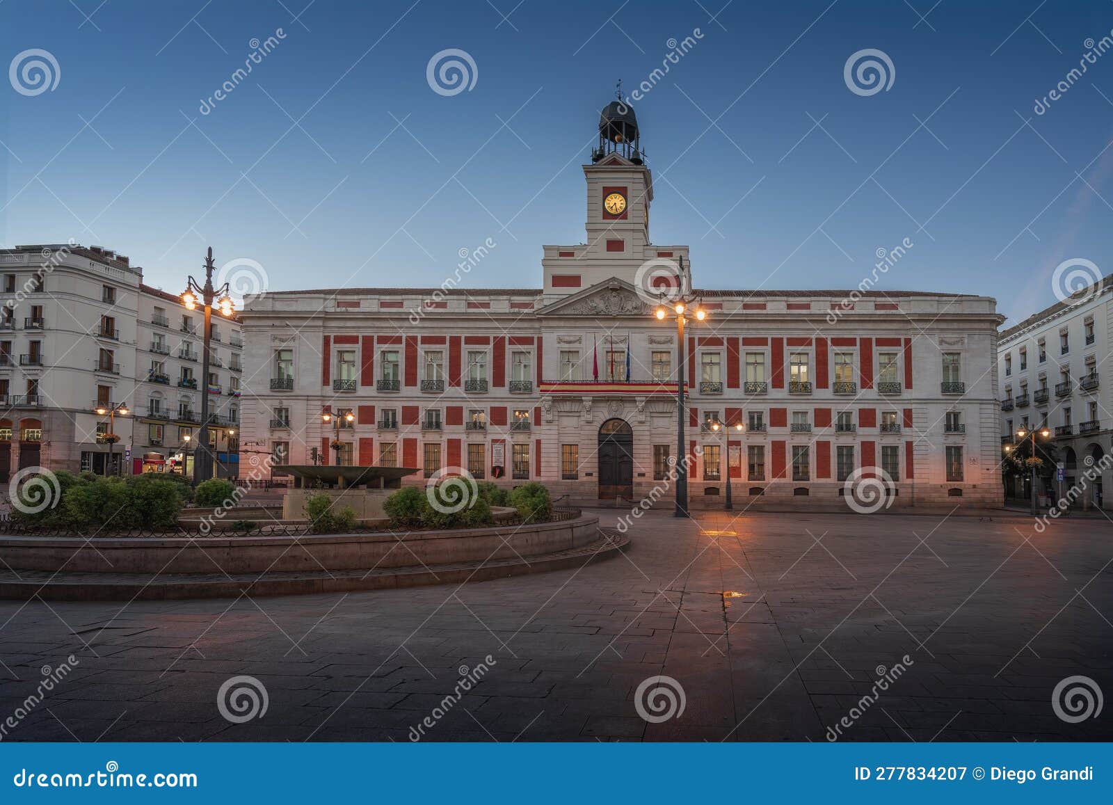 puerta del sol square at sunrise with royal house of the post office (real casa de correos) - madrid, spain