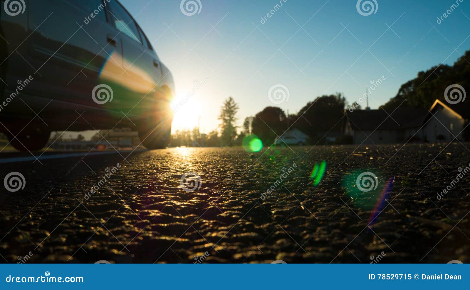 Puesta del sol en el asfalto. Un punto bajo a la perspectiva de tierra tiró tomado en cerca de la puesta del sol que da un grande poniendo en contraste esquema de color azul y anaranjado