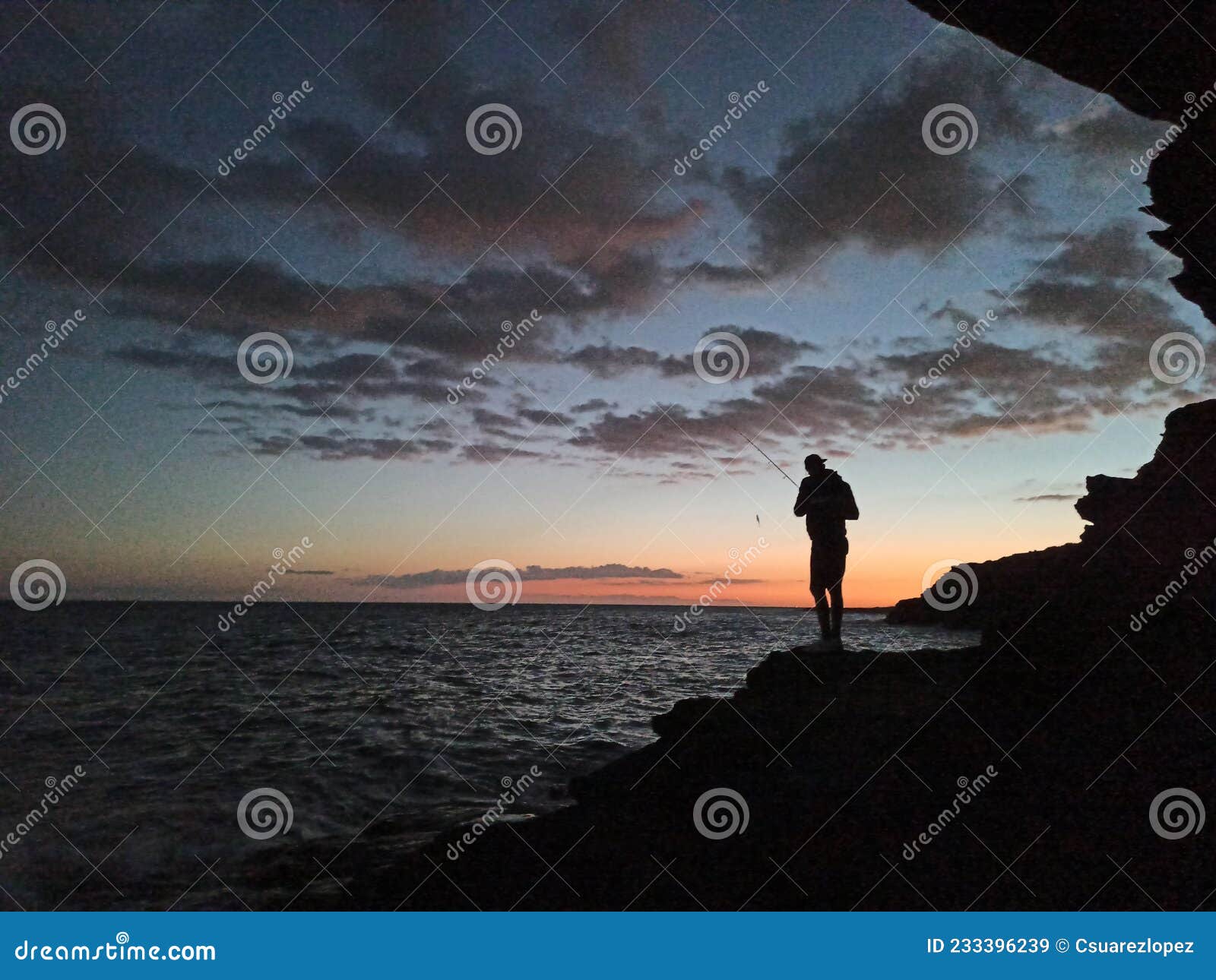 puesta del sol y la silueta del pescando