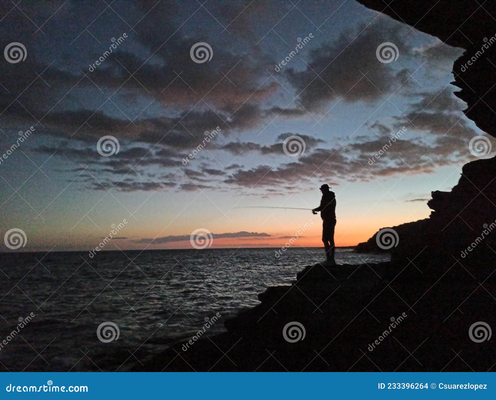 puesta del sol y la silueta del pescando