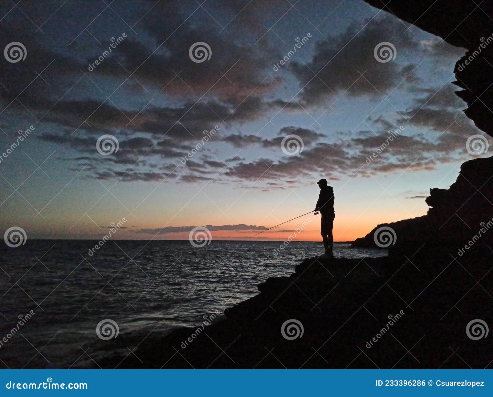 puesta del sol y la silueta del pescando
