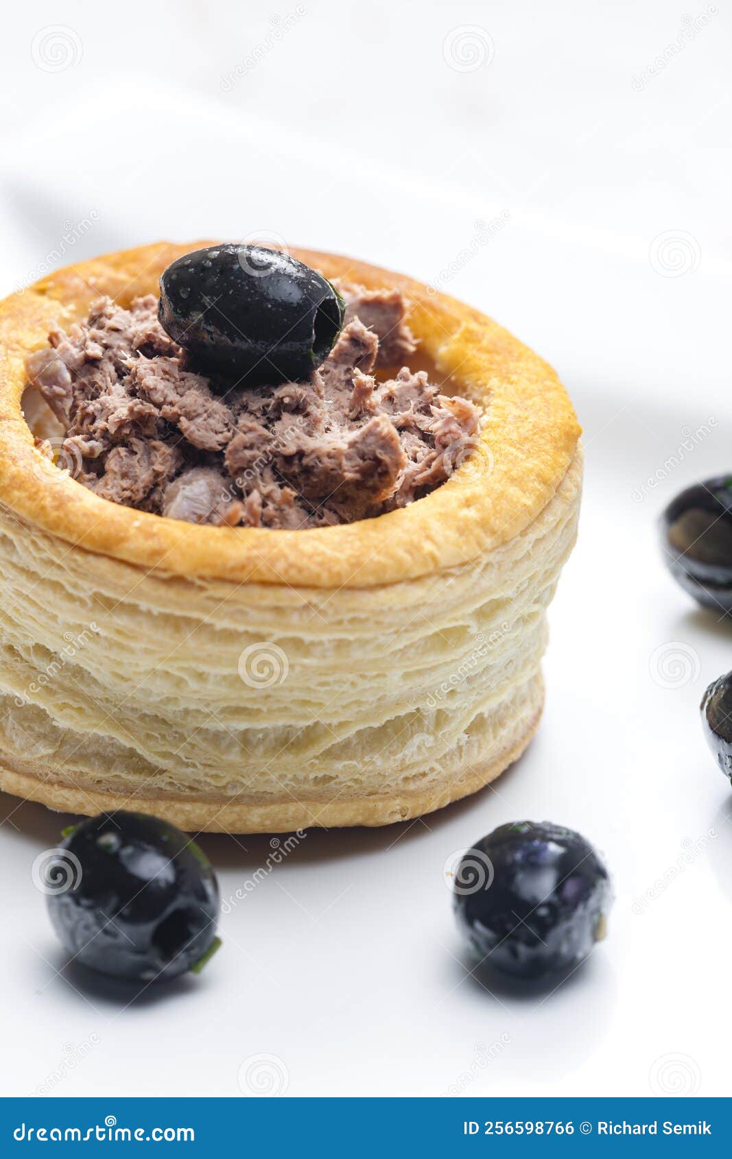 Puff Pastry Filled with Terrine Served with Black Olives Stock Photo