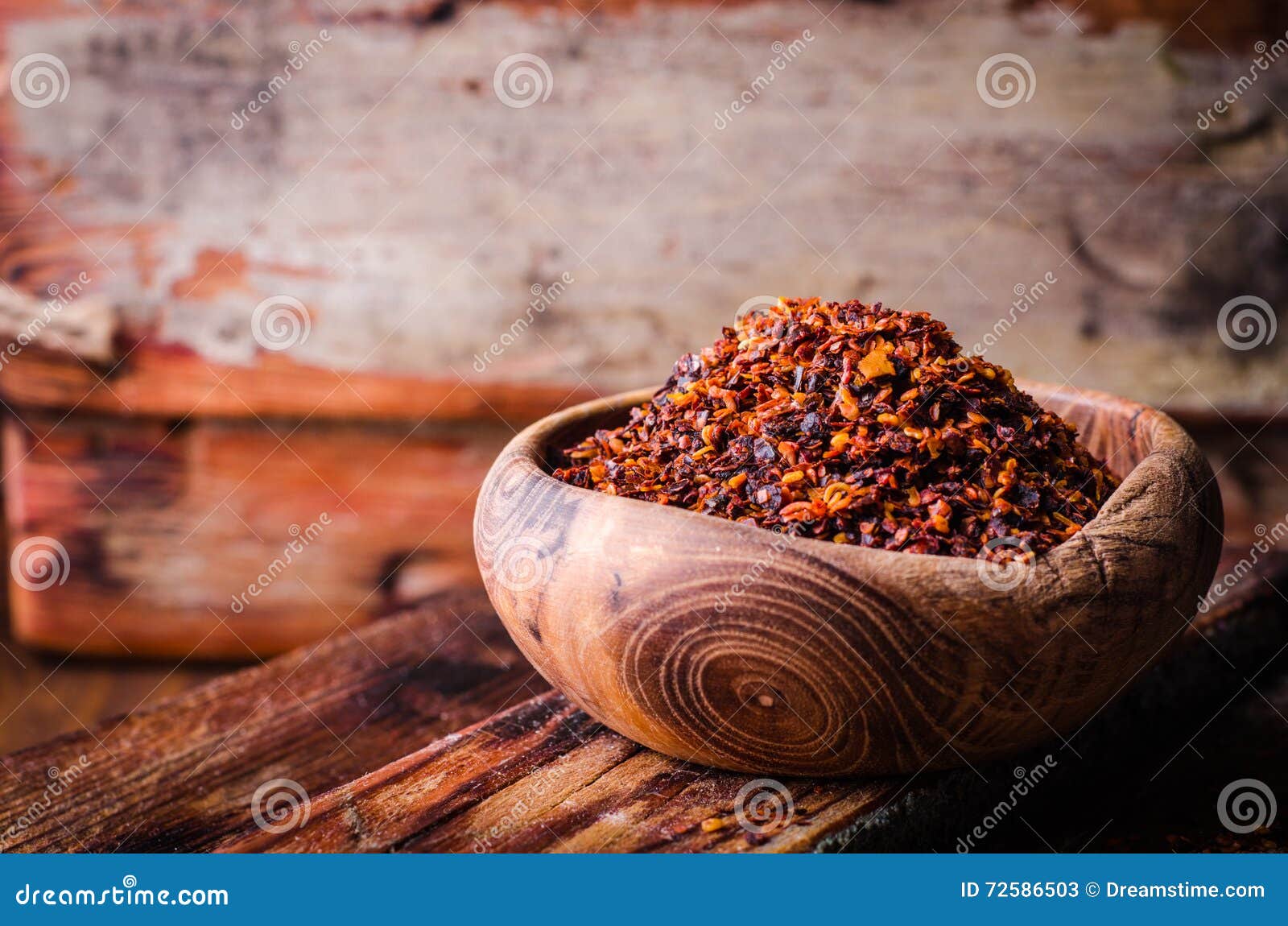 pul biber - crushed red chili pepper in vintage bowl on wooden background. selective focus. toned image. turkish cuisine