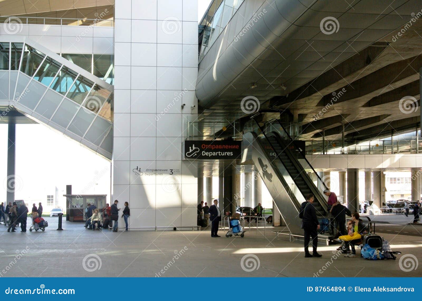 ST PETERSBURG RYSSLAND - MAJ 10, 2016: Pulkovo flygplats, ny terminal Rulltrappa som jämnt lyfter av för `-avvikelse för avtågande passagerare `, Avtågande passagerare kopplar av utomhus, i att vänta på ditt flyg