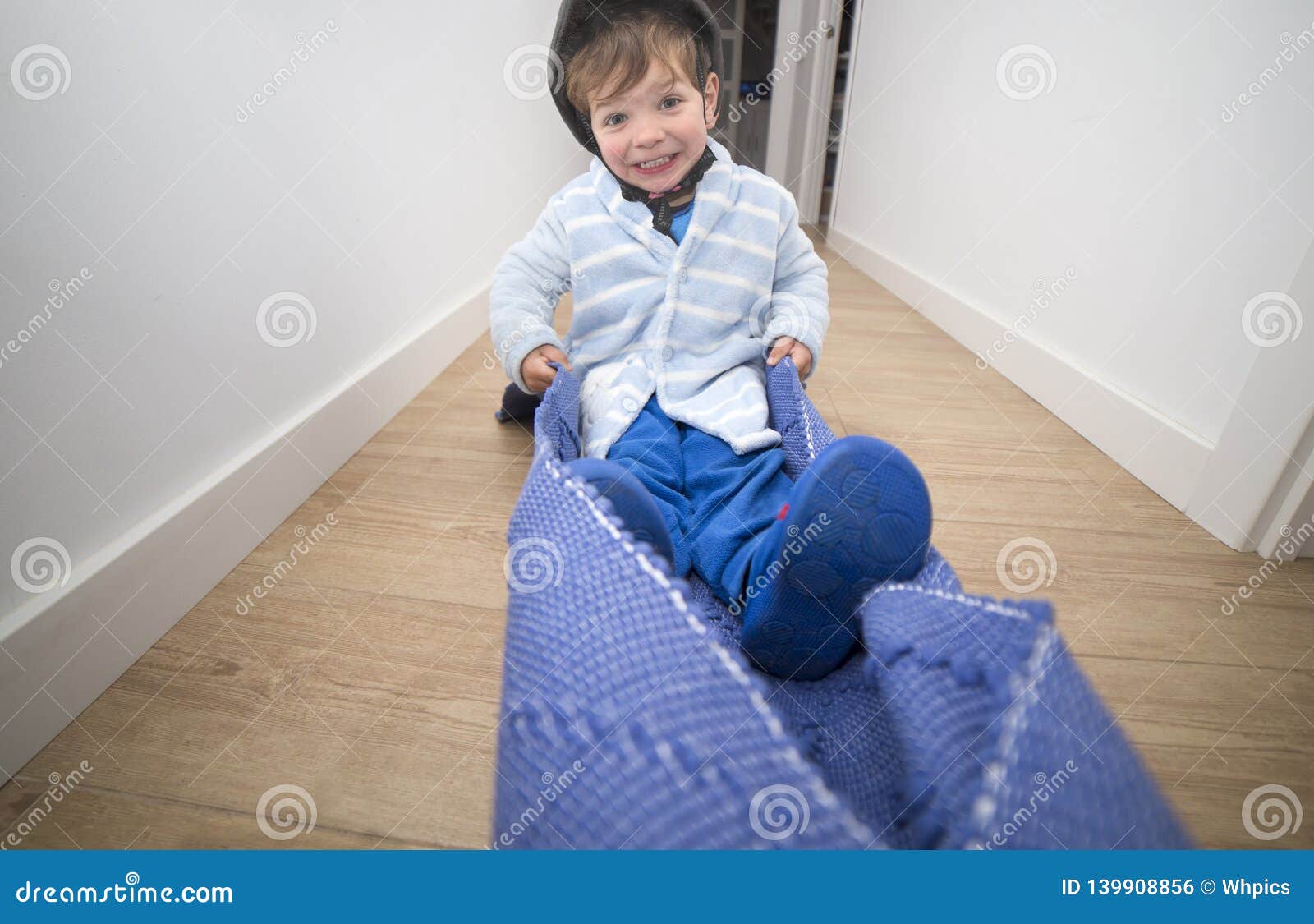 Pulling the Carpet through the Home Corridor with Child Pilot Stock