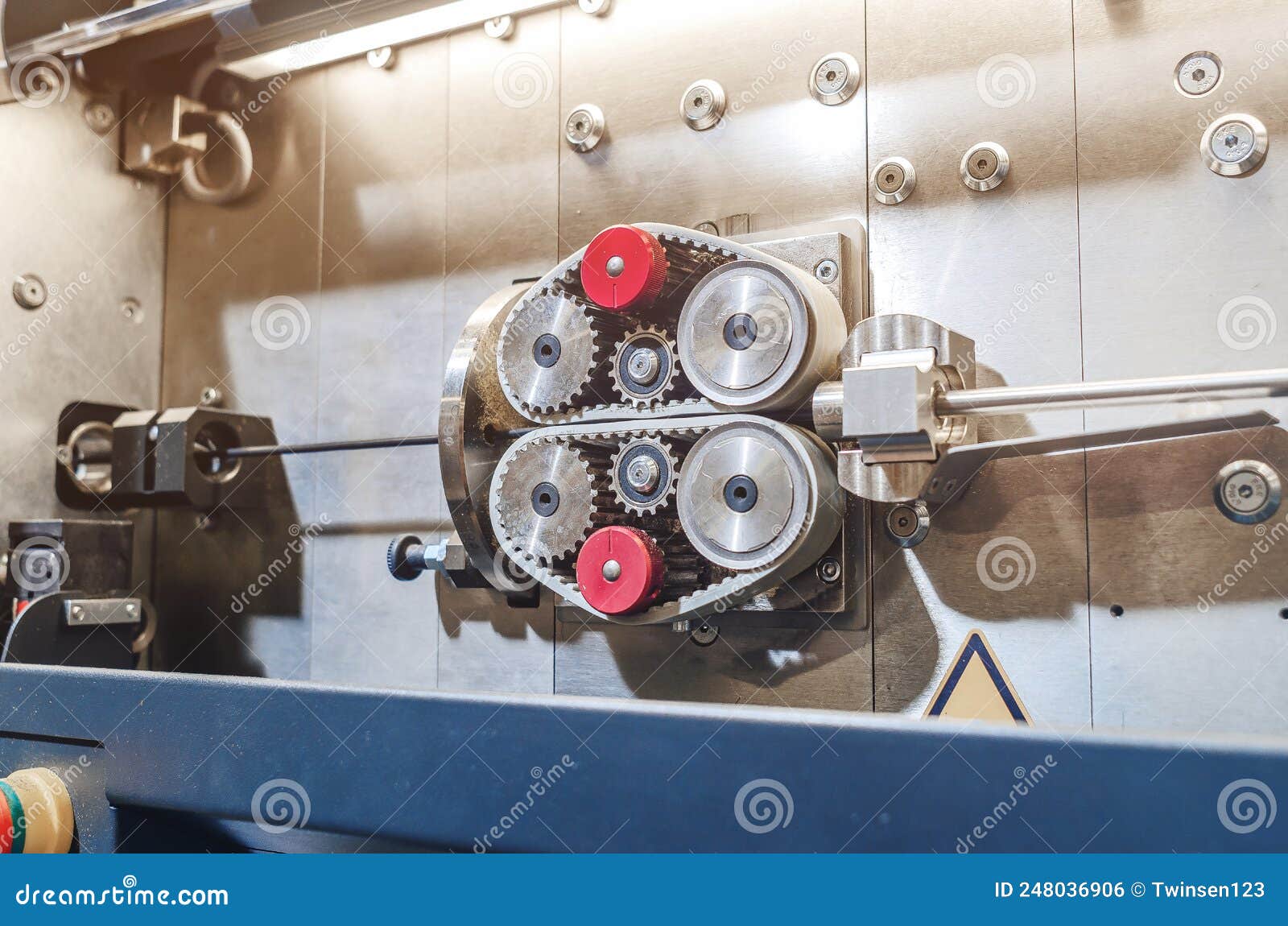 Pulling the Wire through the Gears on the Machine. Part of Industrial
