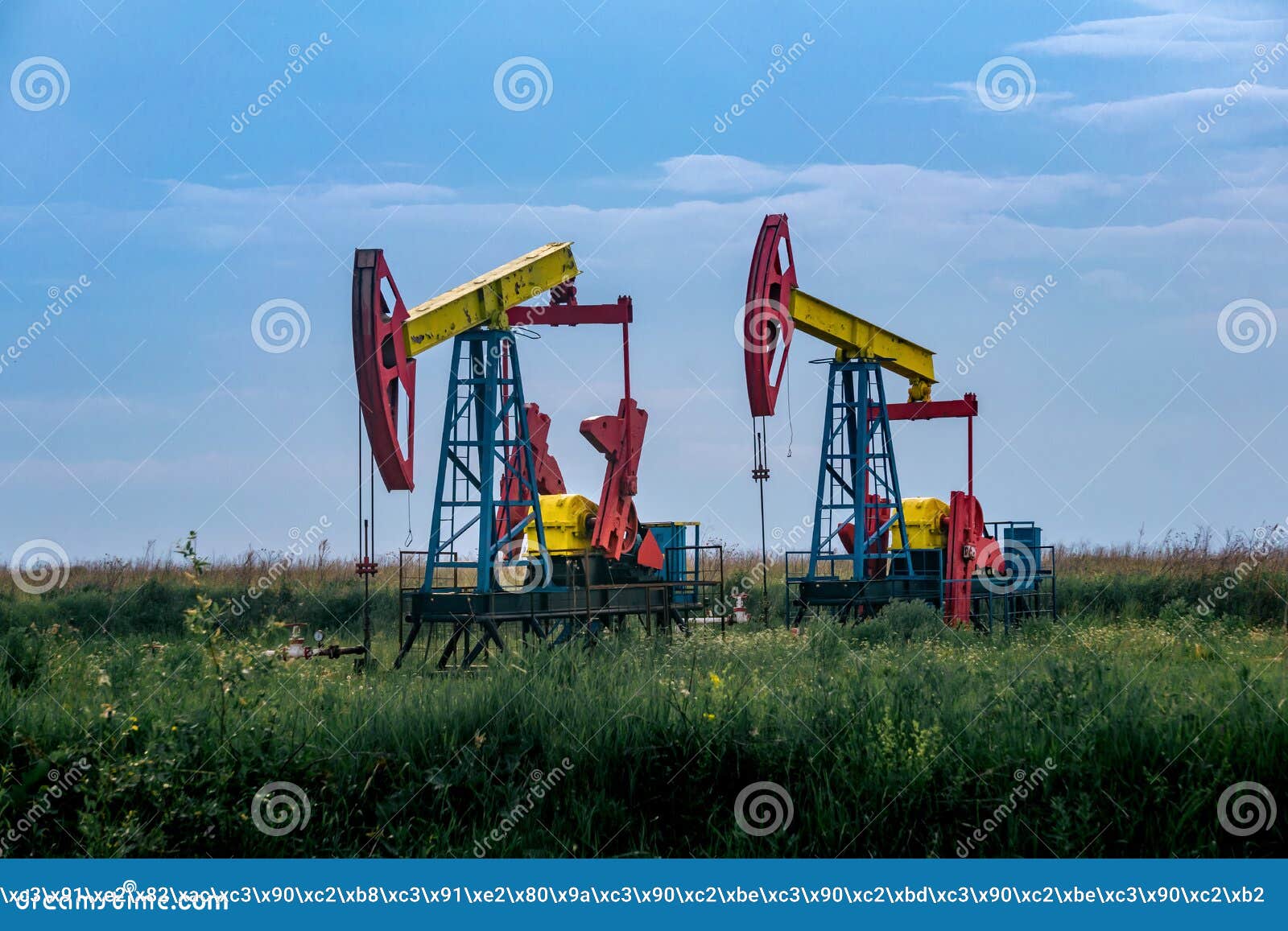 Pumpjacks Operating at an Oil Well in Field Outdoors Stock Photo