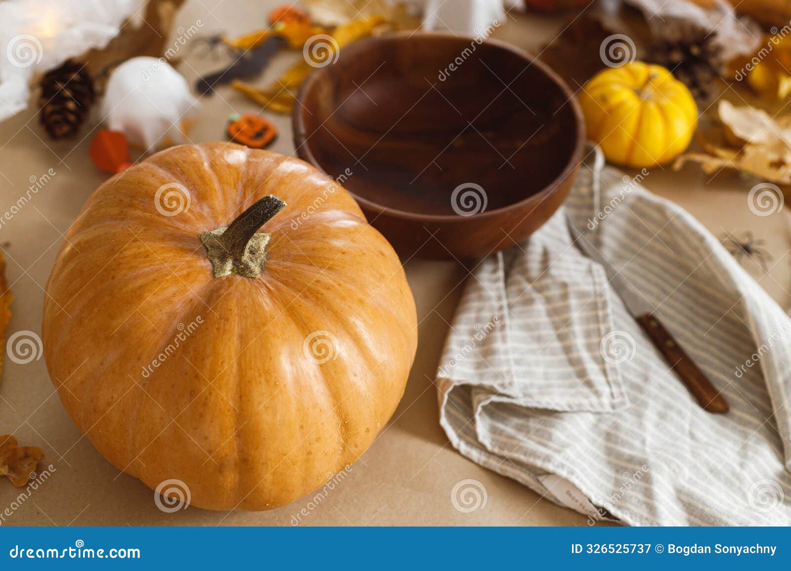 pumpkin and knife, cobweb, ghosts and spiders on table in living room. halloween preparation, carve a pumpkin. making halloween