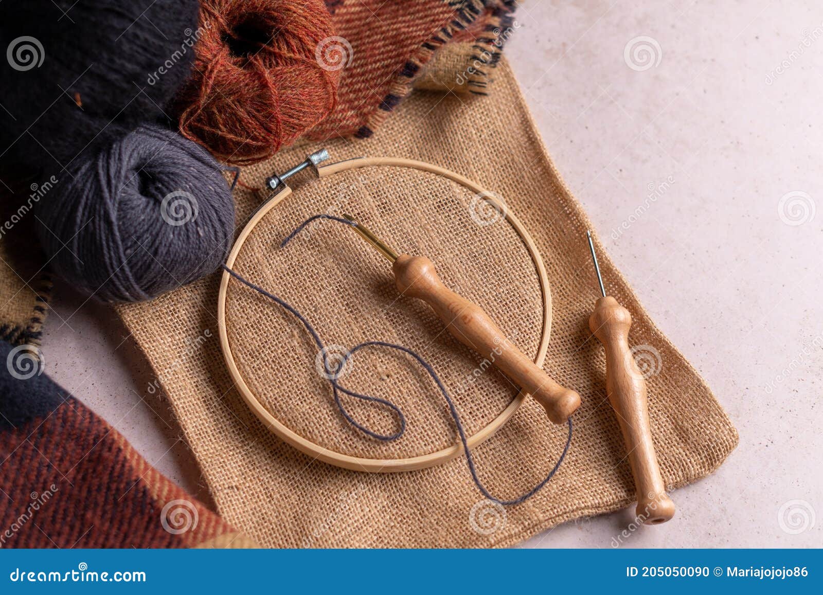 Punch Needle Tool Composition with a Burlap Fabric in a Embroidery Hoop and a Threaded Needle