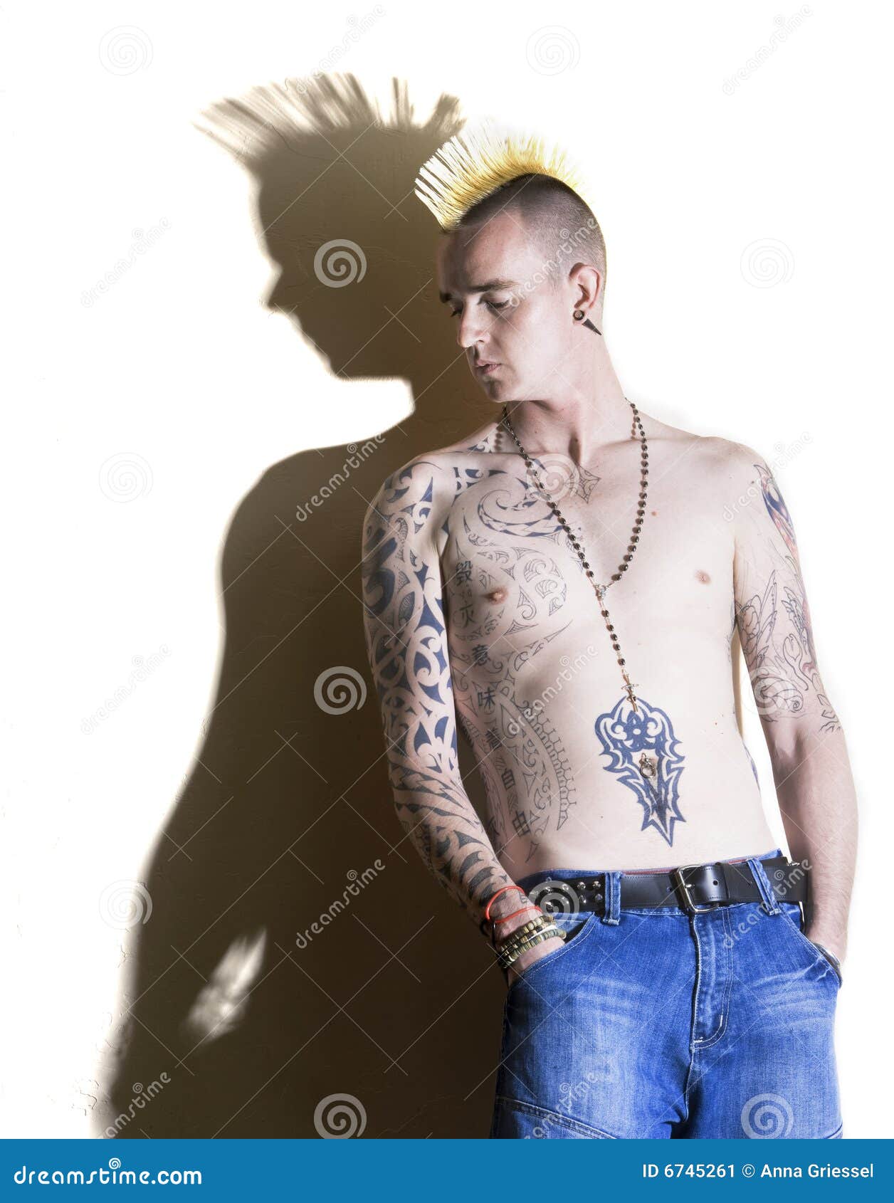 closeup of 18 year old male punk with tattoos wearing leather with green  hair in a mohawk style and dirty face