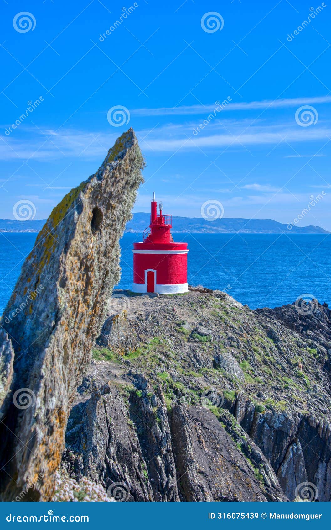 lighthouse in landscape. the iconic red lighthouse at punta robaleira. cabo home, cangas, galicia, spain