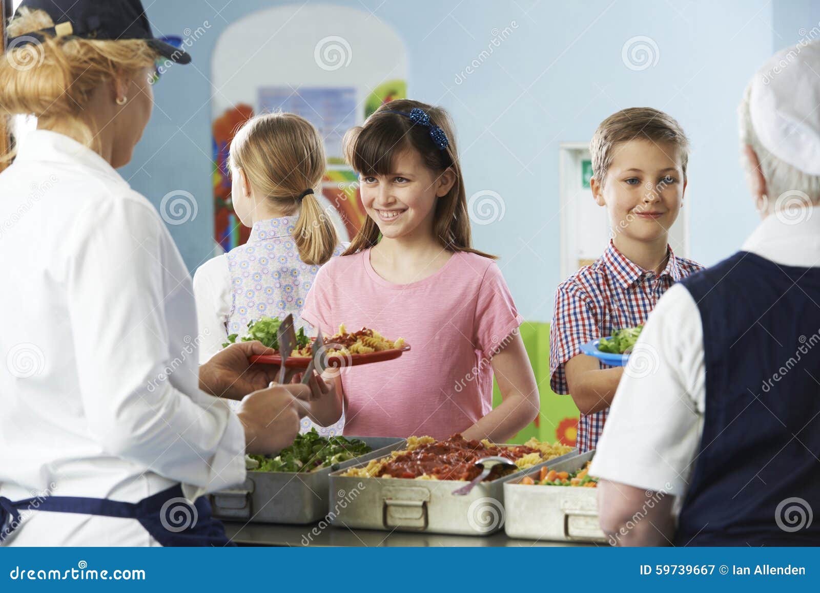 pupils being served with healthy lunch in school canteen