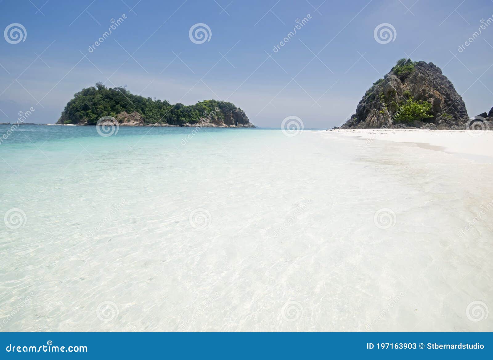 pure white fine sandy sand & shallow blue water with speed boat & cloudless sky at pulau lima besar island, johor, malaysia