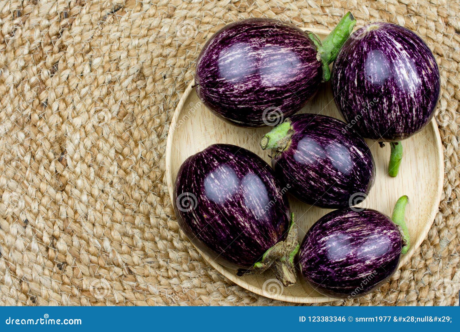 purple eggplant on wooden plate on black background and yute ta