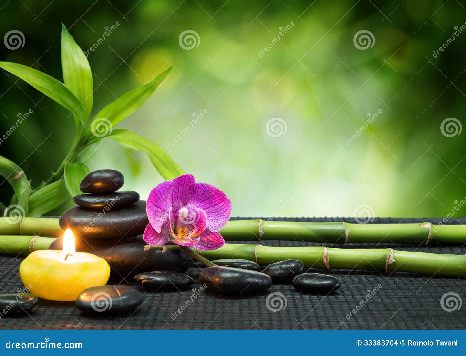 purple orchid, candle, with stones , bamboo on black mat