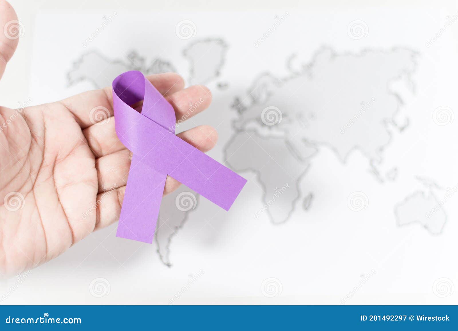 purple ribbon on a person's hand - awareness of violence against women concept