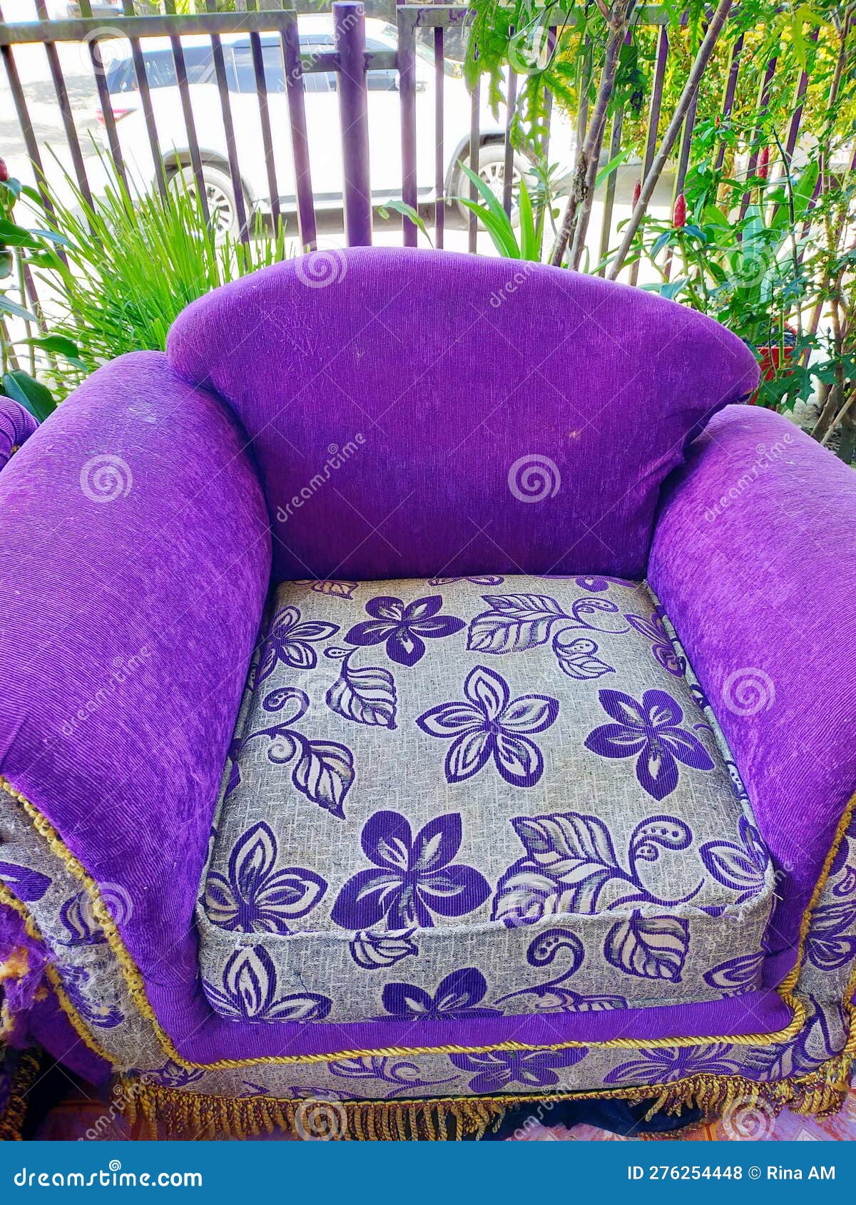 A Purple Single Sofa Chair that is Worn and Damaged with Age Stock