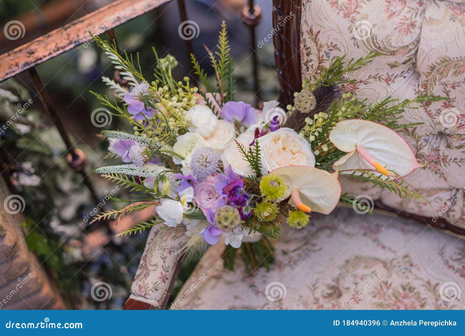 purple and white bride bouquet standing on the chair