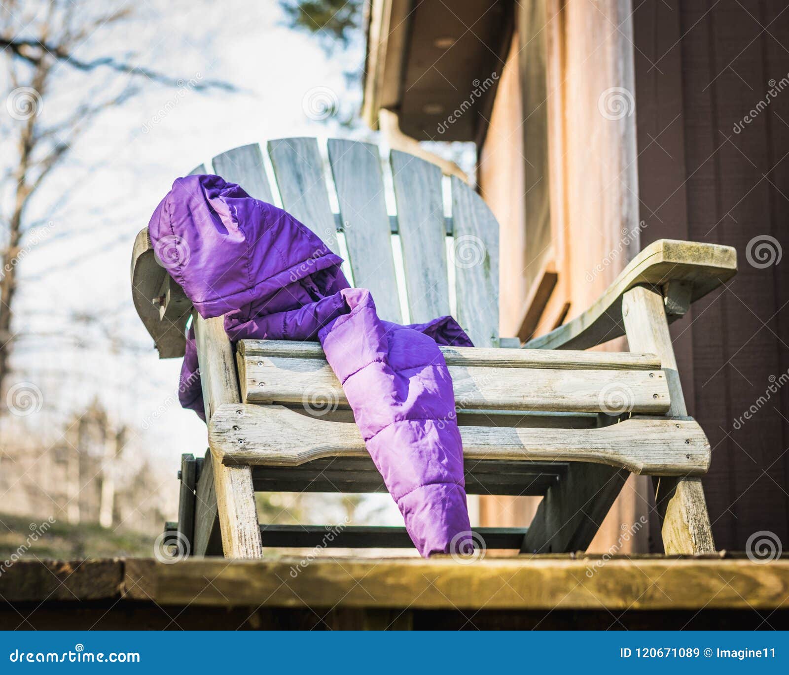 Purple Winter Coat Draped Over An Aqua Adirondack Chair Stock