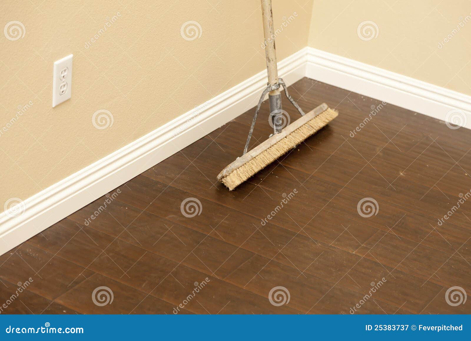 Push Broom On A Newly Installed Laminate Floor And Baseboard Stock