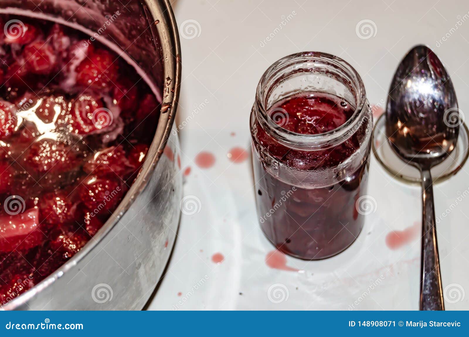 putting cooked strawberyes in the glass jars - shugar adiction
